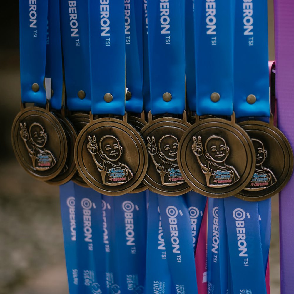 Bronze finisher medals showing a child's face making a peace sign